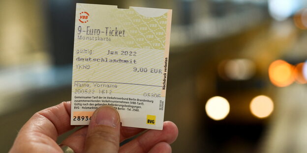Ein Mensch hält ein BVG-Ticket in die Höhe