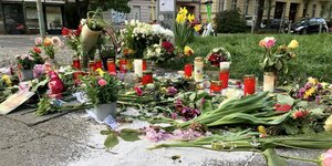 Blumen liegen auf dem Straßenpflaster und erinnern an den Mord in Pankow