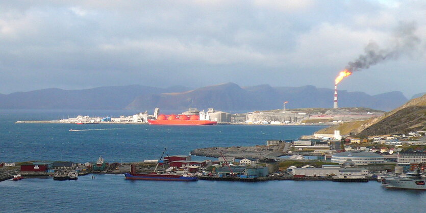 Eine Fabrikanlage, im Vordergrund ein Fjord