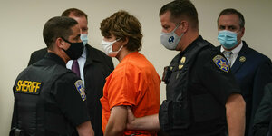 Der Schütze von Buffalo wird im orangefarbenen Häftlingsanzug von Sicherheitskräften vor Gericht geführt