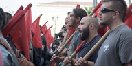 Proteste gegen Polizeigewalt an griechischen Universitäten: Demonstranten stehen in Reihen, einige haben rote Fahnen dabei