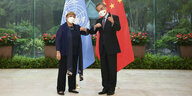 Michelle Bachelt steht neben dem chinesischen Aussenminister und vor den Flaggen der UN und China