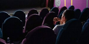 Eine einzelne Zuschauerin in einm Kinosaal