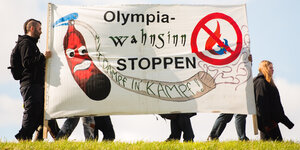 Olympia-Gegner mit Plakat auf einem Deich