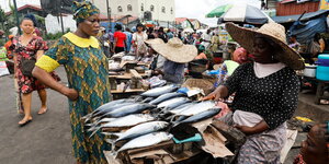 Zwei Frauen stehen sich an einem Fischstand auf einem Markt in Lagos gegenüber.