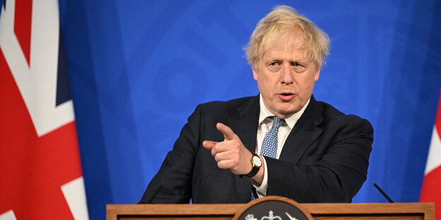 Boris Johnson an einem Rednerpult, im Hintergrund der Union Jack