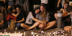 Frauen umarmen sich bei der Trauer um die Getötete