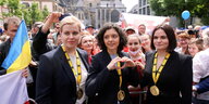 Drei Frauen mit den Orden des Karlspreis posieren für die Kamera