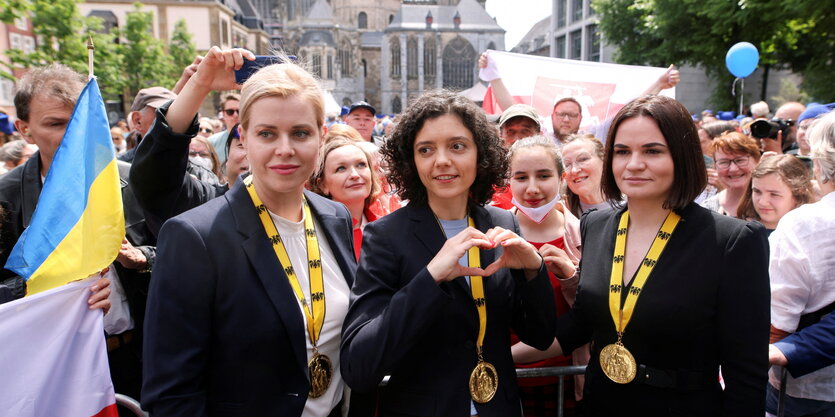 Drei Frauen mit den Orden des Karlspreis posieren für die Kamera