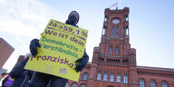 Ein Transparent mit der Aufschrift «Ja zu 59,1%, Wie ist dein Demokratieverständnis, Franziska?» hält ein Teilnehmer einer Protestkundgebung von «Deutsche Wohnen und Co. enteignen» vor dem Roten Rathaus.