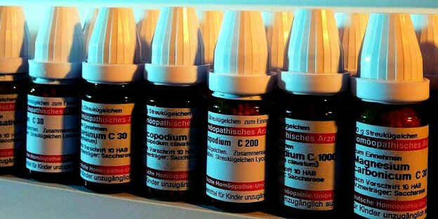 Homöopathische Arzneimittel aufgereiht in einem Regal