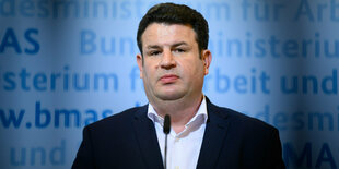 Sozialminister Hubertus Heil guckt bei einer Pressekonferenz in die Kamera