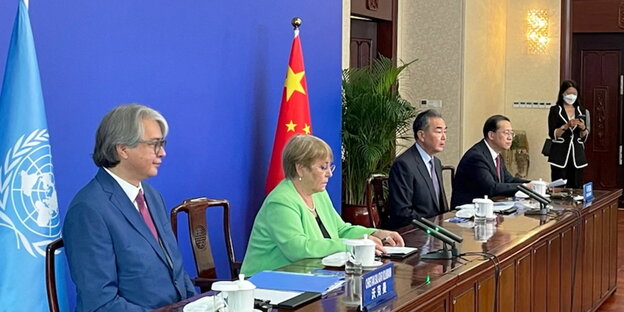 Michelle Bachelet neben Außenminister Wang Yi vor Flaggen im Videogespräch mit Präsident Xi Jinping (nicht im Bild).