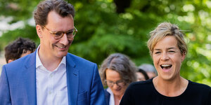 Henrik Wüst und Mona Neubauer lachen vor Pflanzen