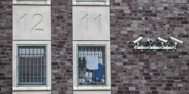 Überwachungskameras hängen in der JVA Düsseldorf an einer Wand mit Zellen.