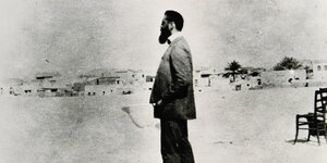 Profilansicht eines Mannes in einer kargen Landschaft auf einem alten schwarzweiß Foto