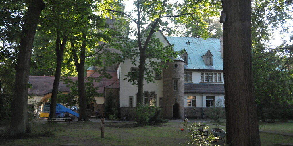 Ein kleines Schloss hinter Bäumen in Sachsen