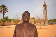 Ein Mann steht vor einer Moschee