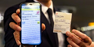 Das 9-Euro-Ticket in digitale Form auf einem Handy und anlag als ausgedruckte Fahrkarte
