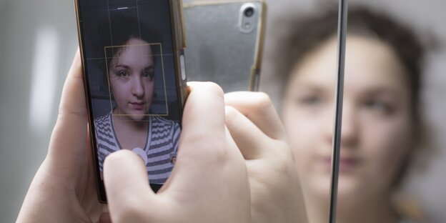 Ein Mädchen fotografiert sich selbst mit seinem Mobiltelefon.
