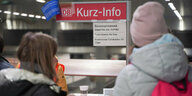 Zwei Menschen stehen vor einer Info-Tafel am Berliner Hauptbahnhof, die über kostenlose Bahntickets für Ukraine-Flüchtlinge informiert