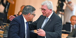 Ministerpräsident Rhein und der ehemalige Ministerpräsident Bouffier umarmen.