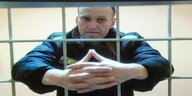 Alexej Nawalny streckt seine Hände durch Gitter