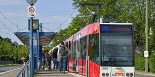 Bielefelder Straßenbahn an Station, im Hintergrund viel Grün.