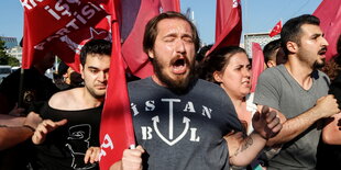 Menschen bei einer Demonstration mit Fahnen.