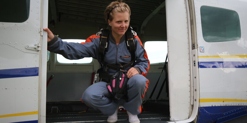 Eine Frau schaut aus der Tür eines Flugzeuges