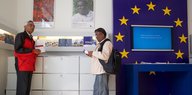 Zwei Männer stehen in EU-Informationsbüro