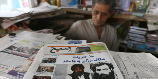 Ein Mann sitzt vor Zeitungen an einem Kabuler Kiosk