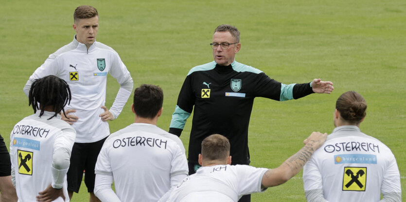 Trainer Rangnick erklärt einer Gruppe von Spielern beim Training etwas