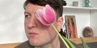 Der Autor Georgy Zeykov hält sich eine Tulpe vor das Gesicht