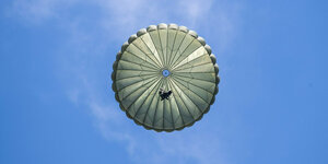 Ein geöffneter Fallschirm an einem strahlend-blauen Himmel