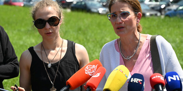 Zwei Frauen bei einer Pressekonferenz unter freiem HImmel