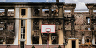Ein Basketballkorb steht vor einem ausgebrannten Gebäude