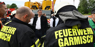 Markus Söder zwischen Feuerwehrleuten