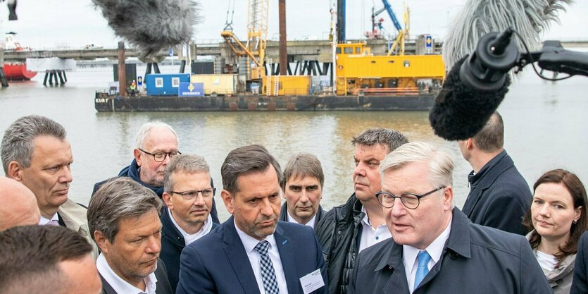 Eine Menschenmenge steht in einem Hafen, darunter Wirtschaftsminister Robert Habeck.