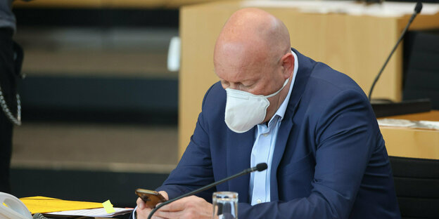Der Politiker Thomas Kemmerich sitzt mit Maske im Landtag von Thüringen