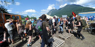 Aktivisti:innen in einem Protestcamp vor dem Hintergrund der Alpen