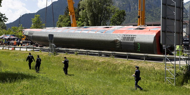 Eine Bahn liegt umgestürzt auf der Strecke