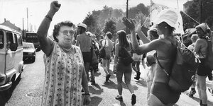 Eine ältere Frau ist im Vordergrund bei einem Friedensmarsch 1981 zu sehen - es ist eine schwarz - weiß Fotografie