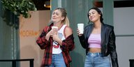 Sophie (Hilary Duff, l.) und Valentina (Francia Raisa) stehen nebeneinander, halten Coffee-To-go-Becher in der Hand und haben die Augen geschlossen