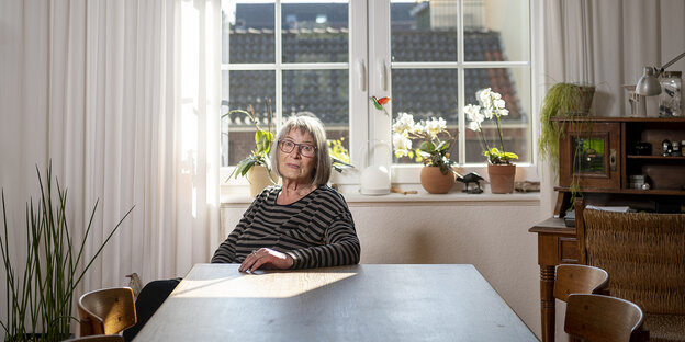 Marianne Teubert sitzt an einem Tisch in ihrere Wohnung