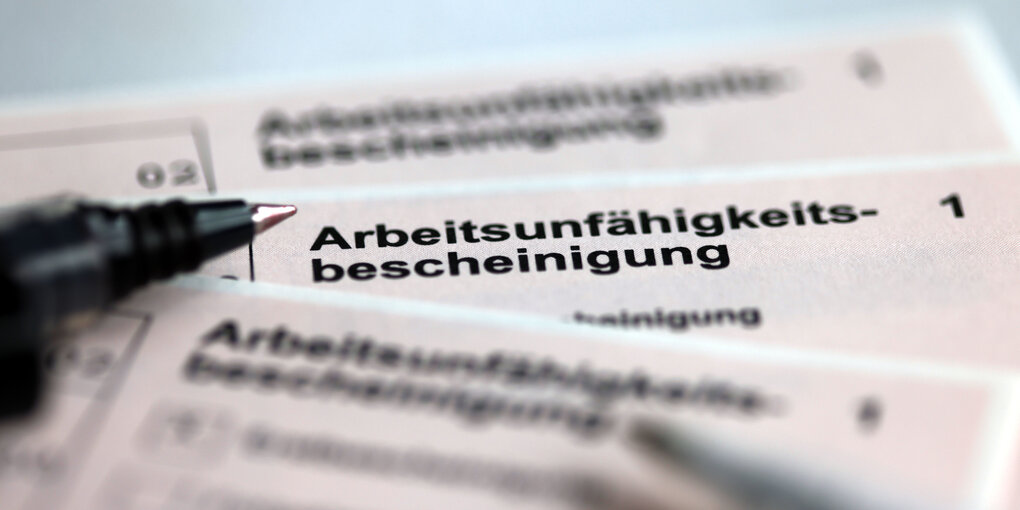 Stifte liegen auf den Arbeitsunfähigkeitsbescheinigungen für Arbeitnehmer im Falle einer Krankschreibung durch den Arzt