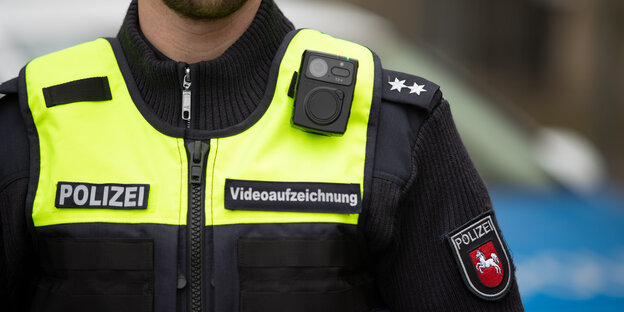 Auf der Brust eines uniformierten Polizisten ist eine Kamera befestigt