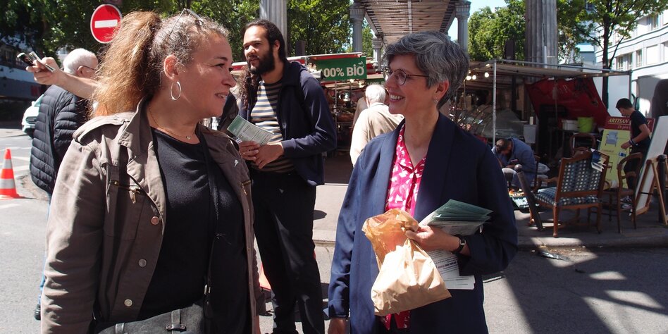 Zwei Frauen unterhalten sich auf einem Markt