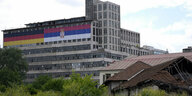 Gebäude mit riesiger serbischer und deutscher Flagge