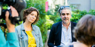 Deniz Yücel und Eva Menasse sitzen in der Nähe des Literaturhauses in Berlin und sprechen mit Journalist:innen